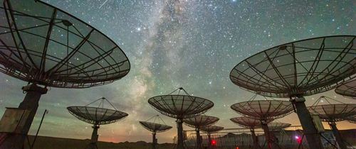 Radio dish array under a night sky, symbolizing wide-area wireless coverage