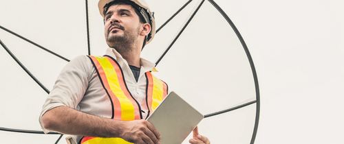 Technician with a satellite dish antenna on site